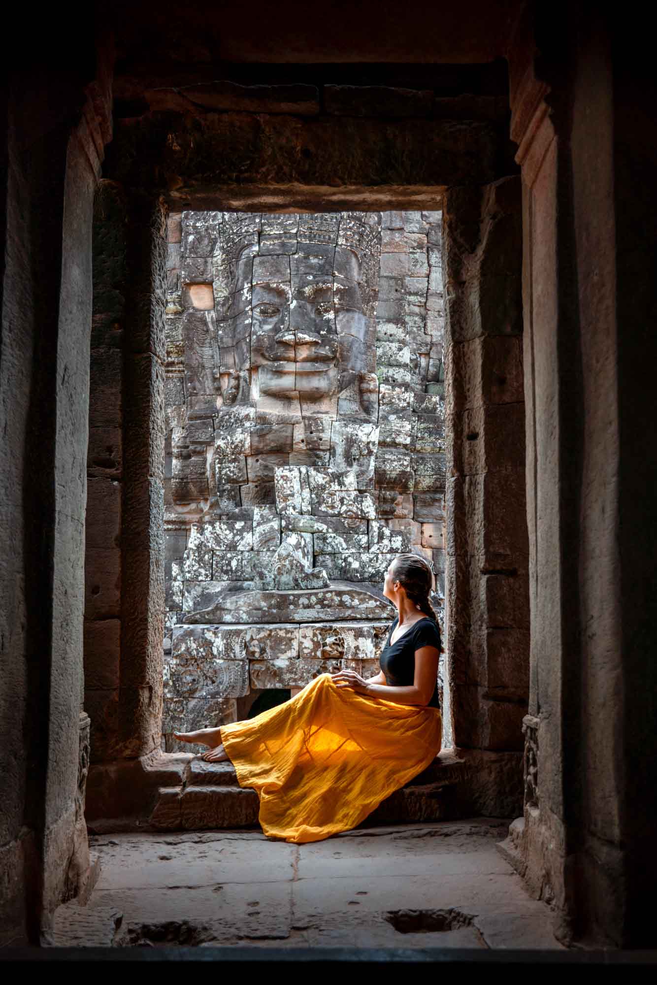 Sophie is sat in the doorway of Bayon Temple to frame the shot