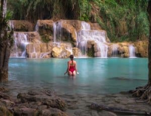 Travels of Sophie wades through the stunning turquoise waters of Kuang Si Falls.