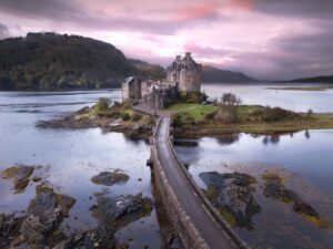 A pink sky sunrise at the most famous and best castle in Scotland, Eilean Donan Castle.