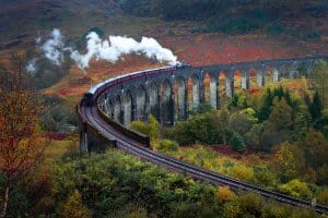 The magical Harry Potter train at Glenfinnan Viaduct rolls through this Autumn scene.