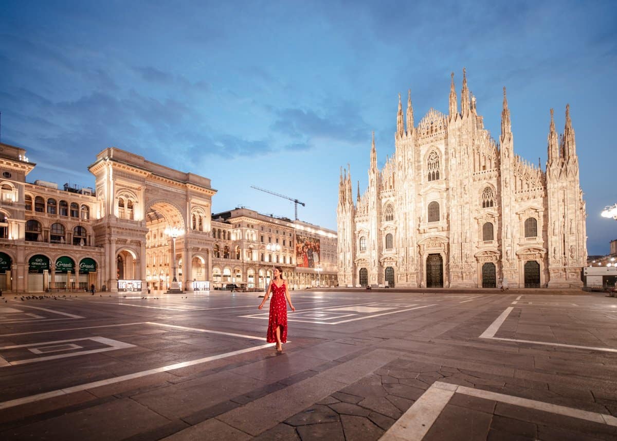 Piazza di Duomo, Milan Cathedral and Galleria Vittorio Emanuele II with a girl in a red dress standing in the middle