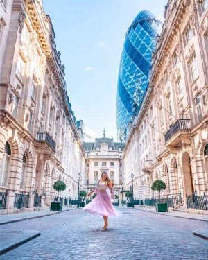 Girl twirling in St Helens Place with the Gherkin building visible behind