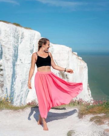 A girl in a pink skirt at a scenic lookout at the White Cliffs of Dover