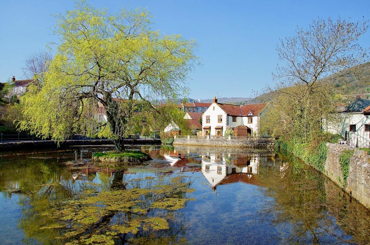 Pretty village of Cheddar, Somerset reflecting in still water.