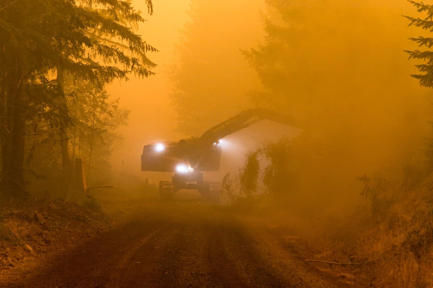 Clean up crews clear emergency evacuation roads following wildfires in the Pacific Northwest.