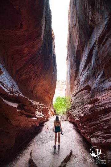 A photo of a girl standing between the narrow walls of Singing Canyon, also known as Long Canyon.