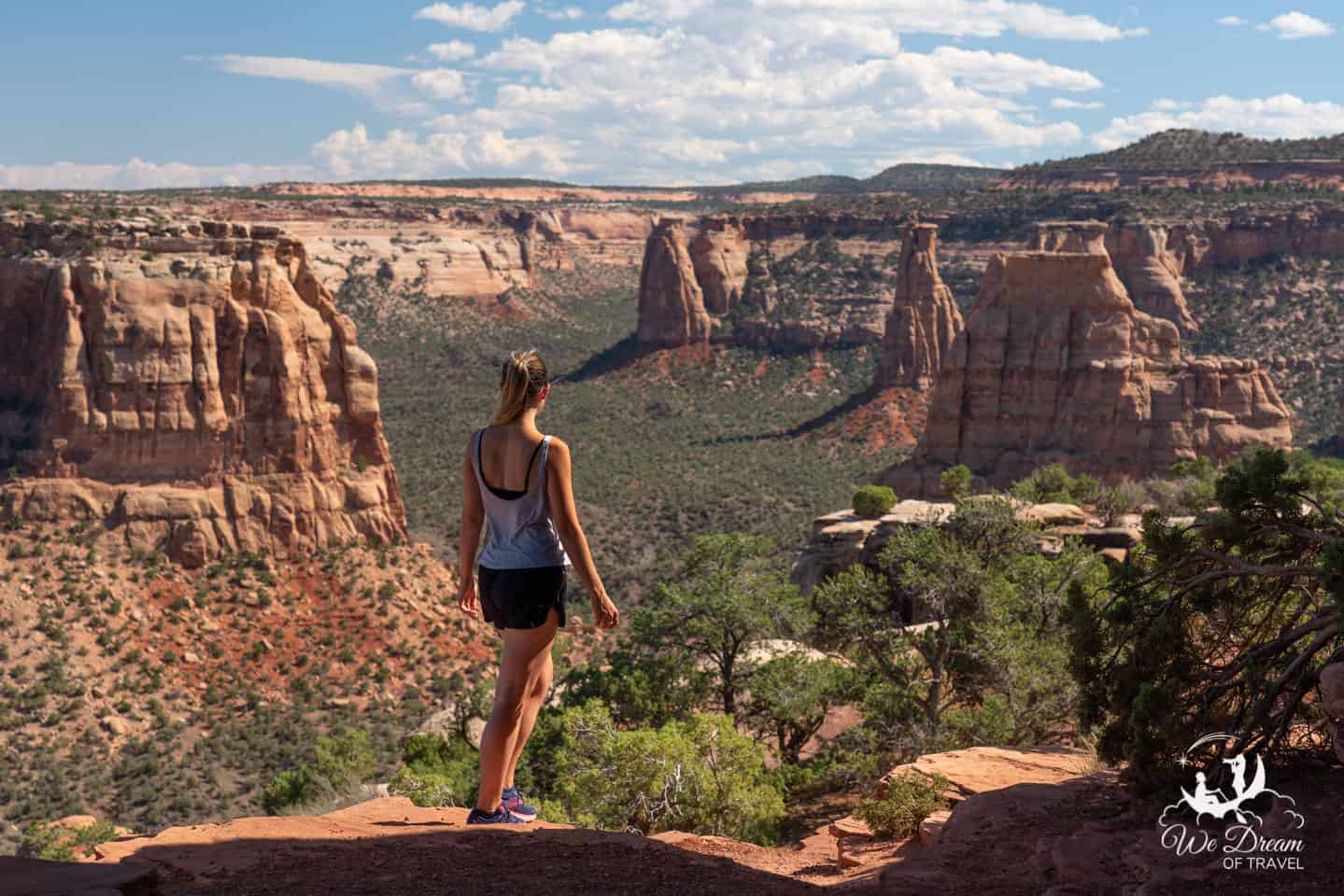 Sophie in hiking gear looking out from Book Cliffs View overlook in Colorado National Park