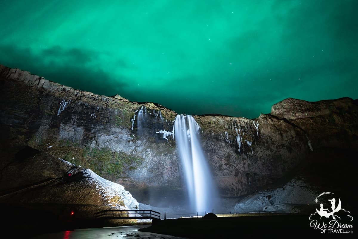 An aurora-filled sky hangs over one of the best waterfalls in Iceland at Seljalandsfoss.