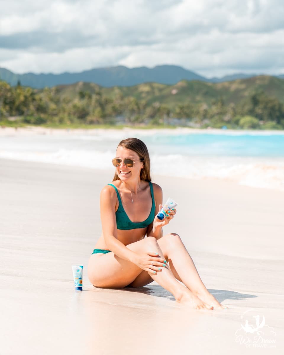 We Dream of Travel writer Sophie Marland is photographed applying reef-safe sunscreen on a beach in Hawaii.