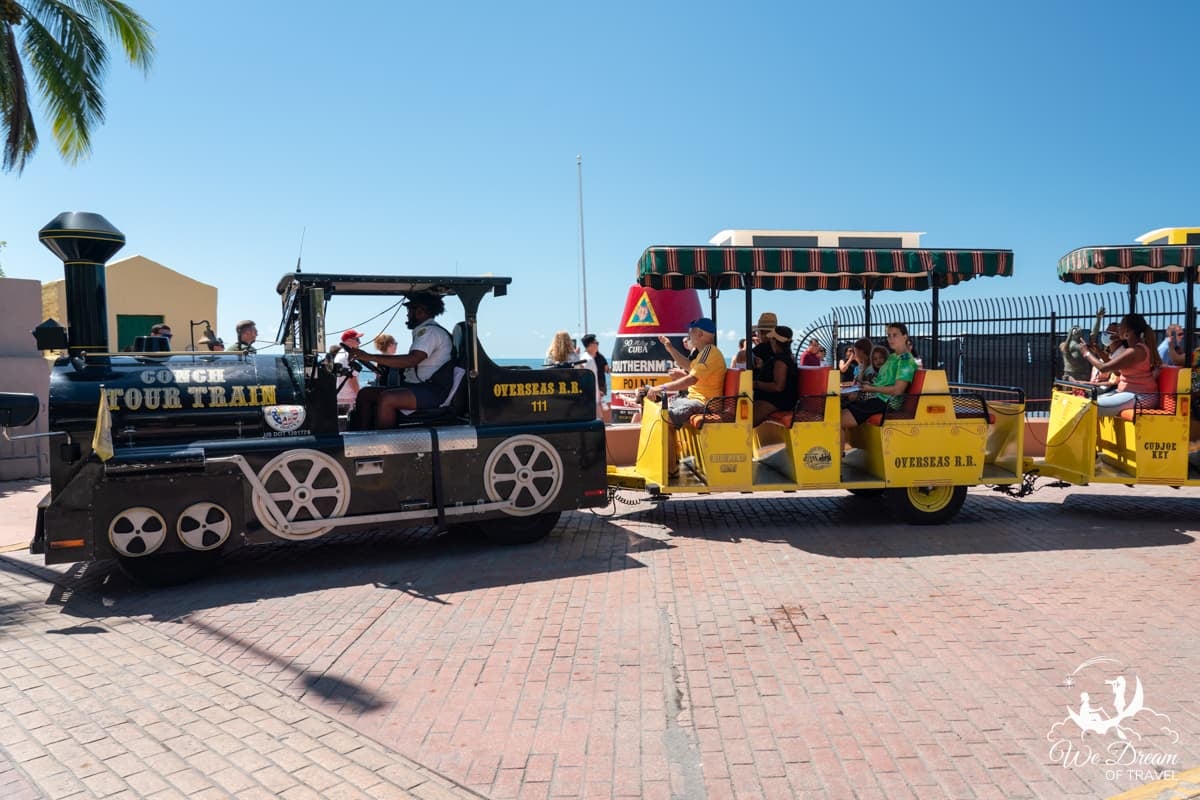 The Conch Train in Key West with passengers in front of the Southernmost Point, Florida Keys