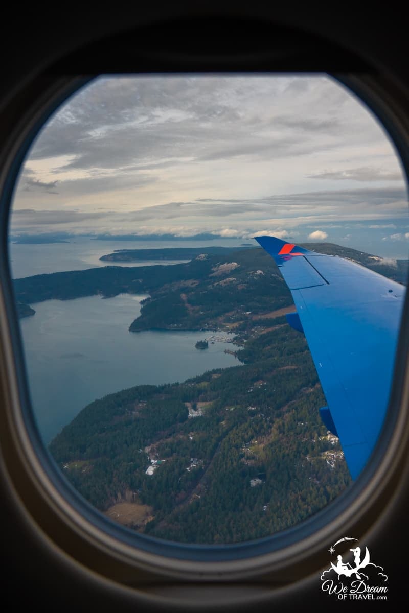A photo framed by an airplane window taken of the San Juan Islands from a Kinect Air flight